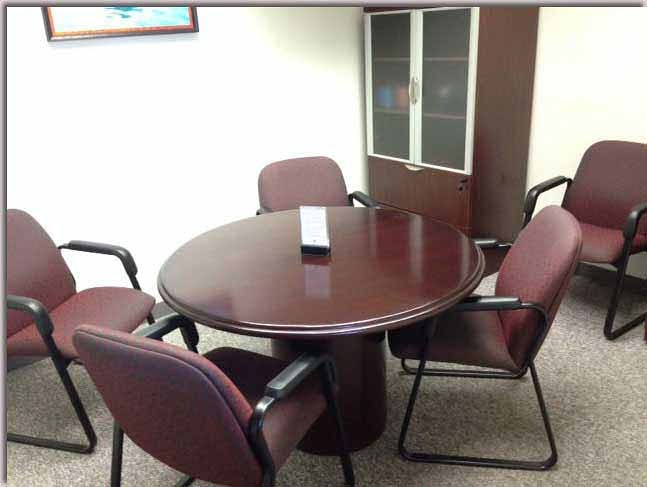Round conference room available as a free deposition suite for pre-deposition preparation.
